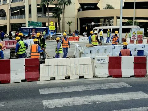 Construction workers in high-visibility vests are busy on a city street Stock-Fotos