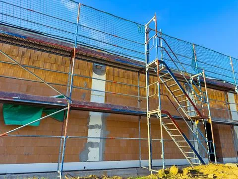 Construction workers improving an exterior wall at a building site during a.. Fotos de archivo