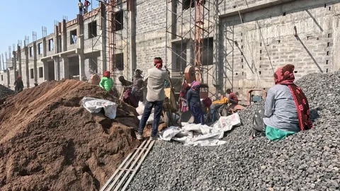 Construction Workers at Industrial Building Site with Sand and Gravel Piles Stock Footage 344477648