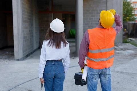 Construction workers inspecting building site progress, architect and forem.. Stock Photos