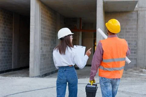 Construction workers inspecting building site progress, teamwork and expert.. Stock Photos