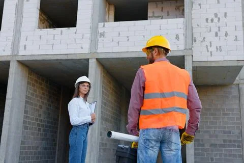 Construction workers inspecting building site progress, architect and forem.. Stock Photos