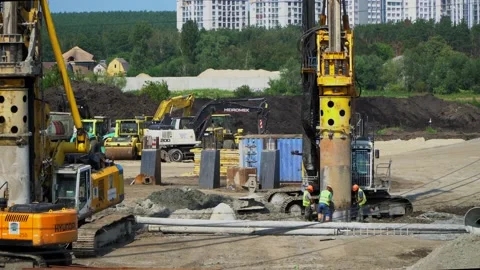 A construction workers inspects the bridge piers. Big drilling machine making Stockbeeldmateriaal 221256810