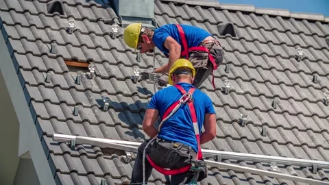 Construction Workers Instal Railing for Solar Panel Mounting on Sloped Roof Stock Footage 150195909