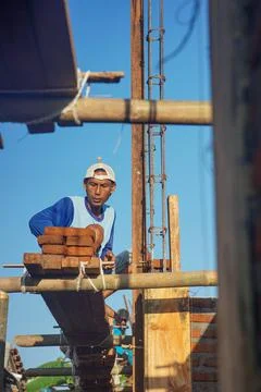 Construction workers install bricks and cement from rows of bricks on exterio Stock Photos