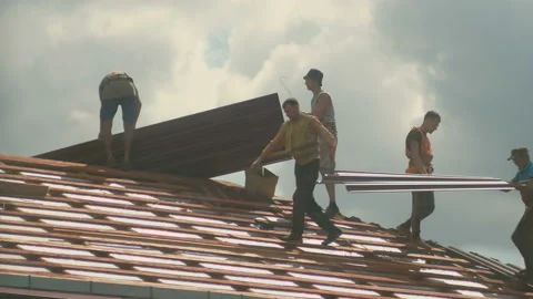 Construction workers install a new metal roof on a house Stock Footage 130251776