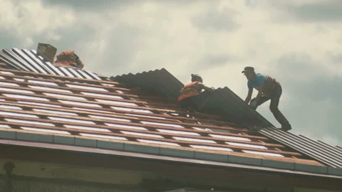 Construction workers install a new metal roof on a house Stock Footage 130255781
