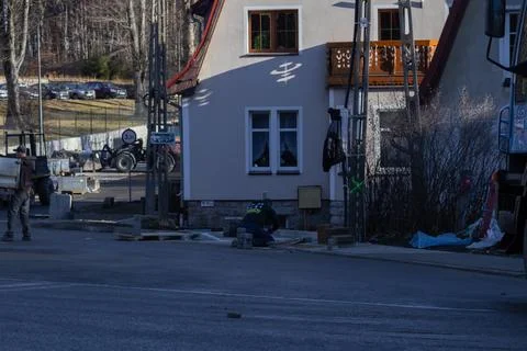 Construction workers install stone pavement blocks on a sidewalk near a Stock Photos