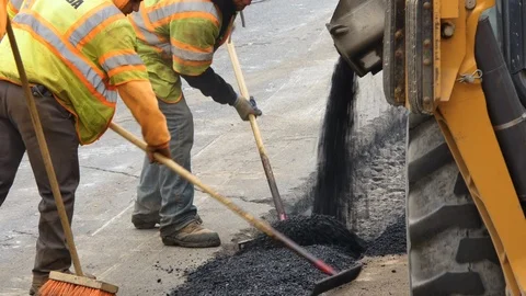 Construction workers installing asphalt patch on road close up shot Stock Footage 106364969