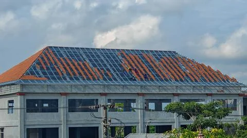 Construction Workers Installing Clay Roof Tiles on Steel Frame Building Stock Photos