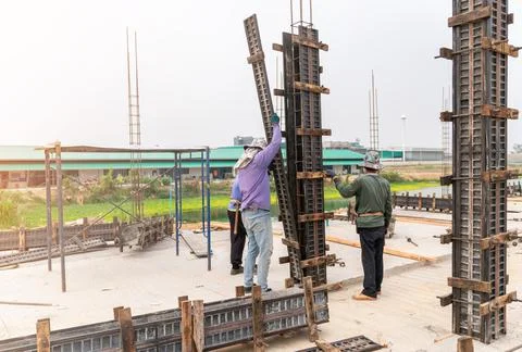 Construction workers installing formwork column pillar Stock Photos