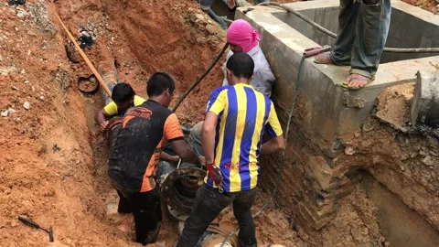Construction workers installing new water pipe at the construction site Stock Footage 100708886