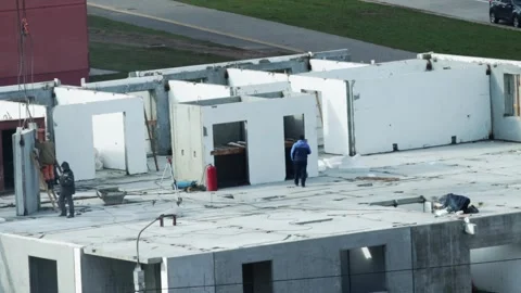 Construction workers installing precast concrete wall panels on building top Stock Footage 344864276