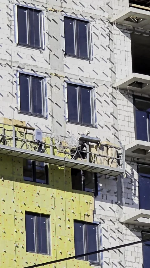 Construction workers installing thermal insulation on building facade Stock Footage 314210236