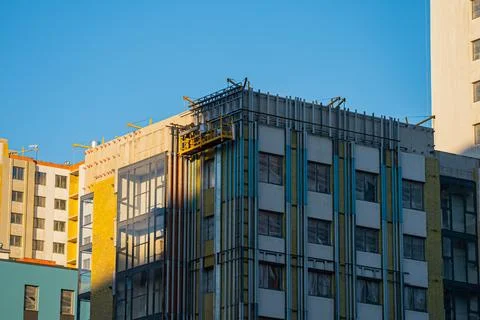 Construction workers installing thermal insulation on building facade Stock Photos