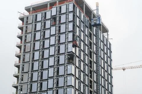 Construction workers installing windows on a high-rise building under const.. Stock Photos