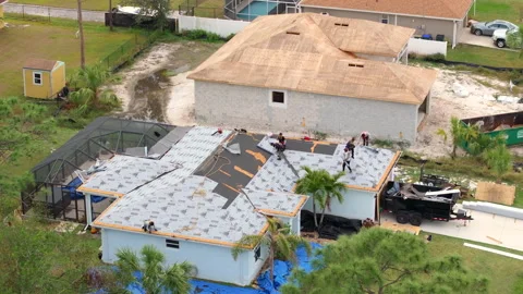 Construction workers laying asphalt shingles on rooftop. Private house roof Stock Footage 329141615