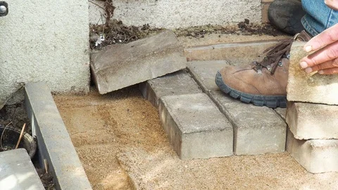 Construction workers laying concrete pavement on the street, with hammer in hand Stock Footage 112929895