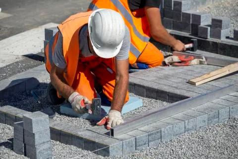 Construction workers laying paving bricks outdoor Foto stock