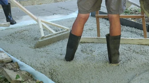 Construction workers leveling fresh wet concrete for a foundation Video stock 342703008