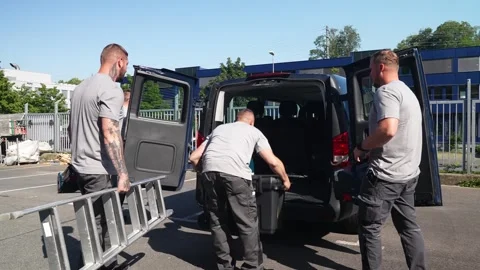 Construction workers loading equipment and ladder into service van before job Stock Footage 331305218