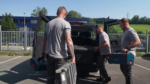 Construction workers loading toolboxes and ladder into van before starting Stock Footage 331305213