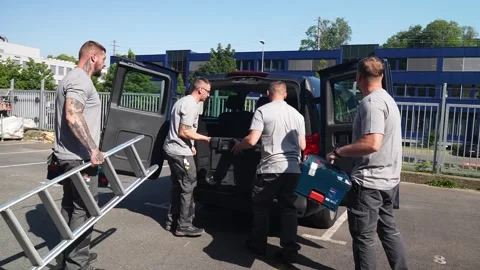 Construction workers loading tools and equipment into van before starting work Stock Footage 331305063