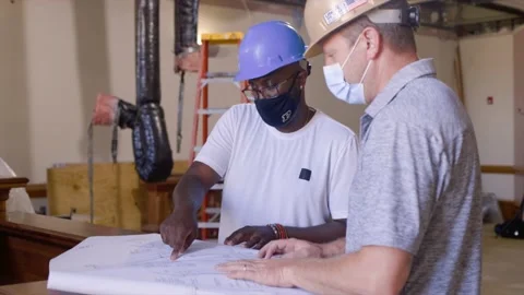 Construction Workers Look at Blueprints in Room Stock Footage 146104566