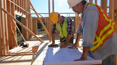 Construction workers looking over plans together Stock Footage