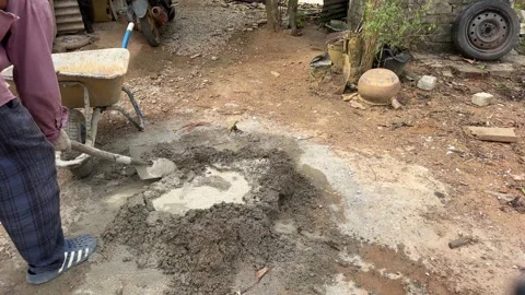 Construction Workers Mixing Cement in Rural Development Site Stock Footage 329593321