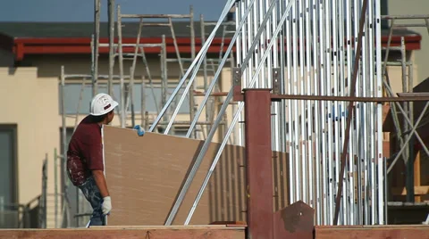 Construction workers move drywall to the metal frame at construction site Video stock 34578424