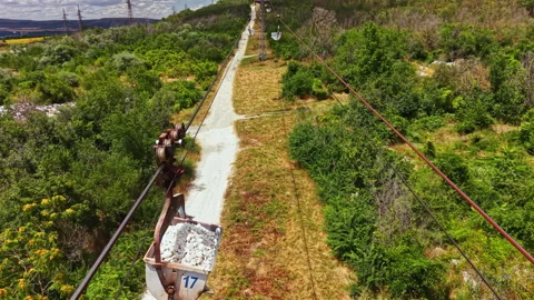 Construction workers move materials using a cable system in a forest area near a Stock Footage 341130503