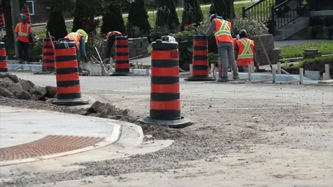 Construction workers in neon orange yellow vests and hard hats building sidewalk Stock Footage 249101671