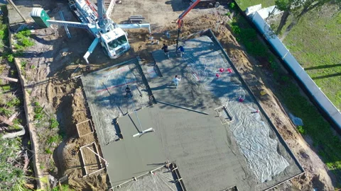 Construction workers at new house building site pouring concrete of flat slab Stock Footage 309150834