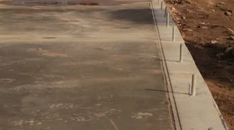 Construction workers on newly poured slab Stock Footage 21558440