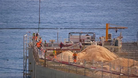 Construction Workers on Offshore Platform with Sand and Machinery in 4K Video stock 315275240
