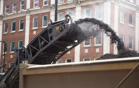 Construction workers operate a cold milling machine. Stock Photos