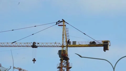 Construction workers operate a crane at a building site in the city during dayti Stock Footage 331245308
