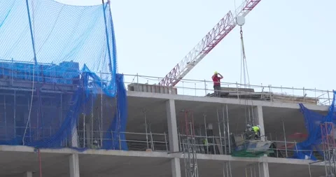 Construction workers operating crane on residential building site in Madrid Stock Footage 335652275