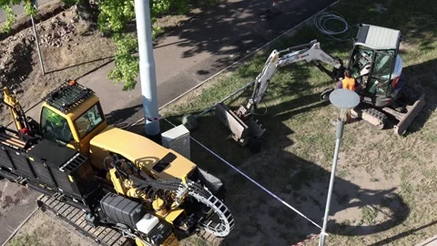 Construction workers operating excavator and drilling machine on urban site prep Stock Footage 315159476