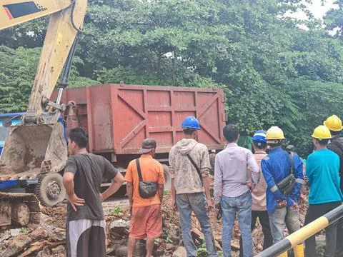 Construction Workers Operating Excavator and Dump Truck at Roadwork Site Fotos Stock