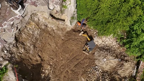 Construction workers operating heavy excavator, digging garden hole near re.. Stock Footage 314980505