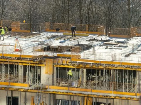 Construction workers operating on a high-rise building site with rebar grids Stock Photos