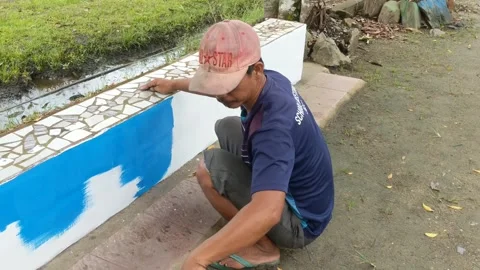 Construction workers painting garden seating Stock Footage 262539464