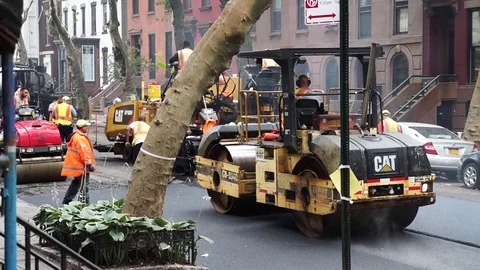Construction workers paving a residential road with steam roller on city street Stock Footage 80206603