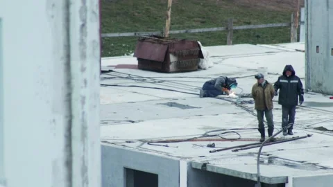 Construction workers perform welding on concrete slab of unfinished building Stock Footage 342922844