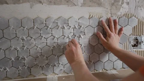 Construction workers placing hexagonal tiles on wall Stock Footage 317262666