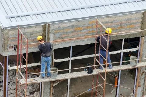 Construction workers plaster wall Stock Photos