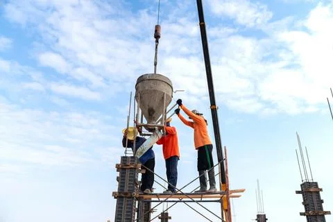 Construction workers pour concrete column at the construction site. Foto stock