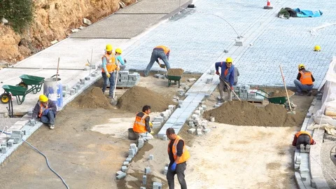 Construction workers pour concrete mix from cement mixer and trowel flat Vidéo 87804596